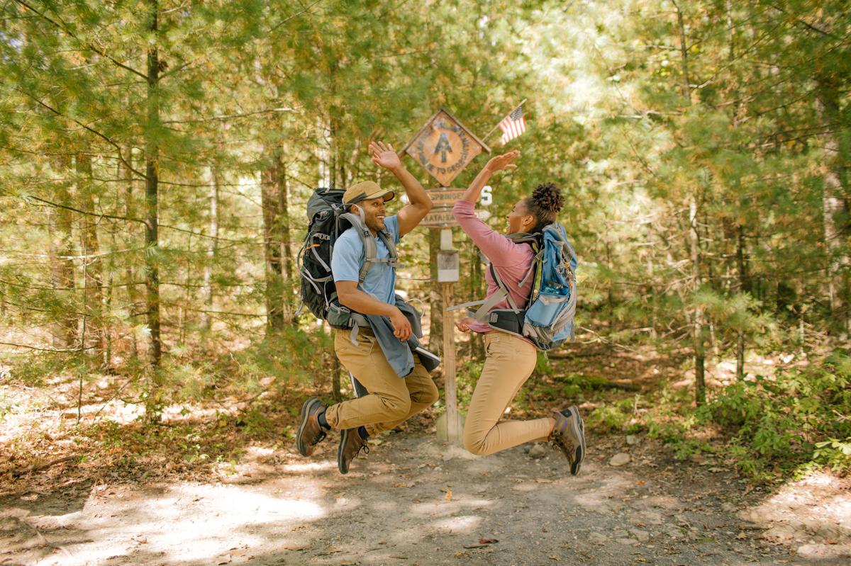 Couple Jumping And High Fiving On The Appalachian Trail 