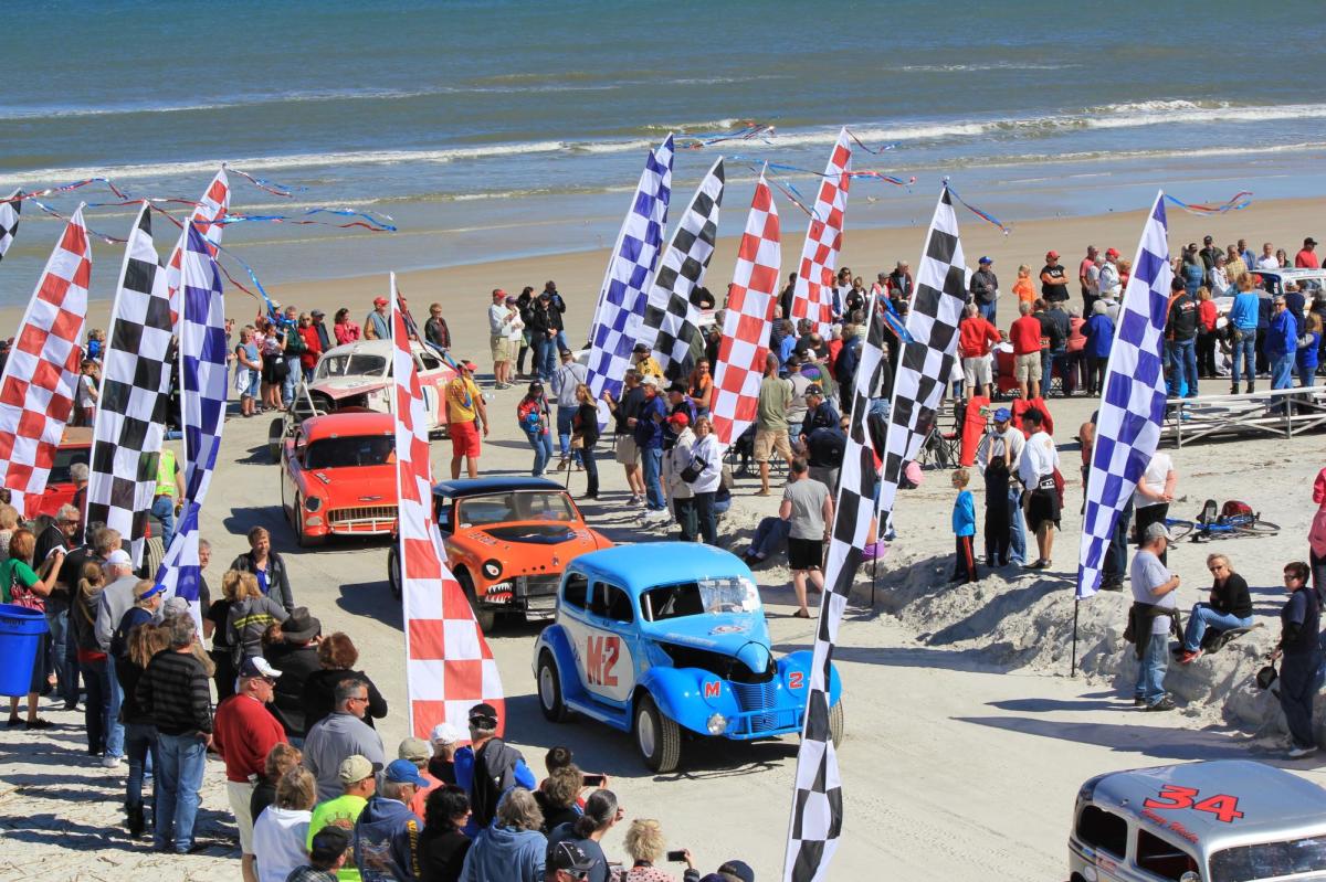 Former beach racing cars cross the finish line during the Historic North Turn Beach Parade