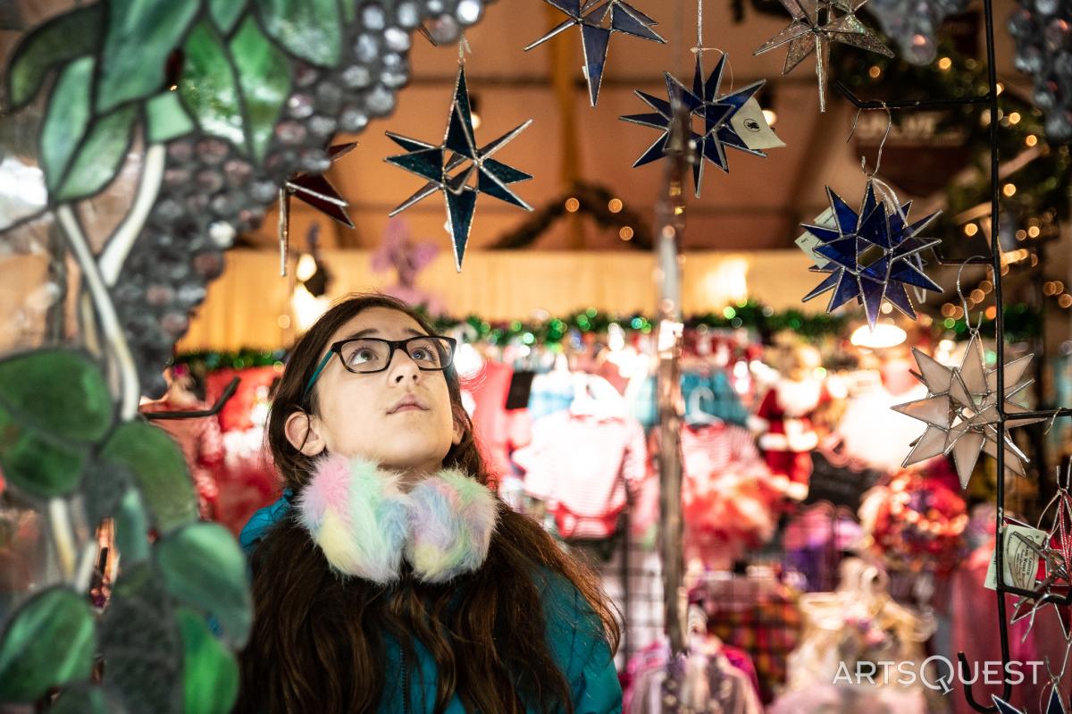 A young shopper looks up at Star ornaments at Christkindlmarkt in Bethlehem, Pa.