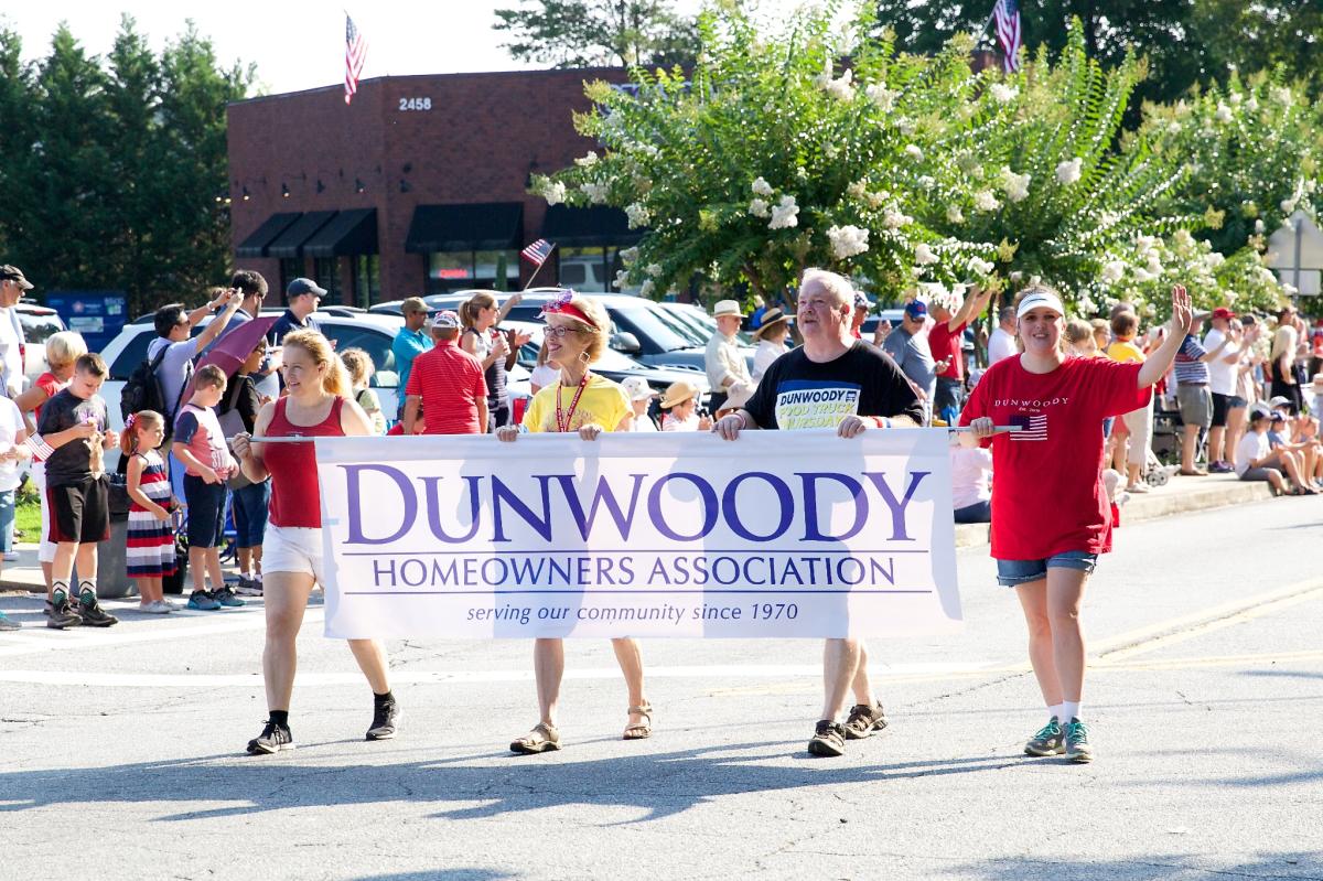 Dunwoody Homeowners Association July 4th Parade Walking holding sign