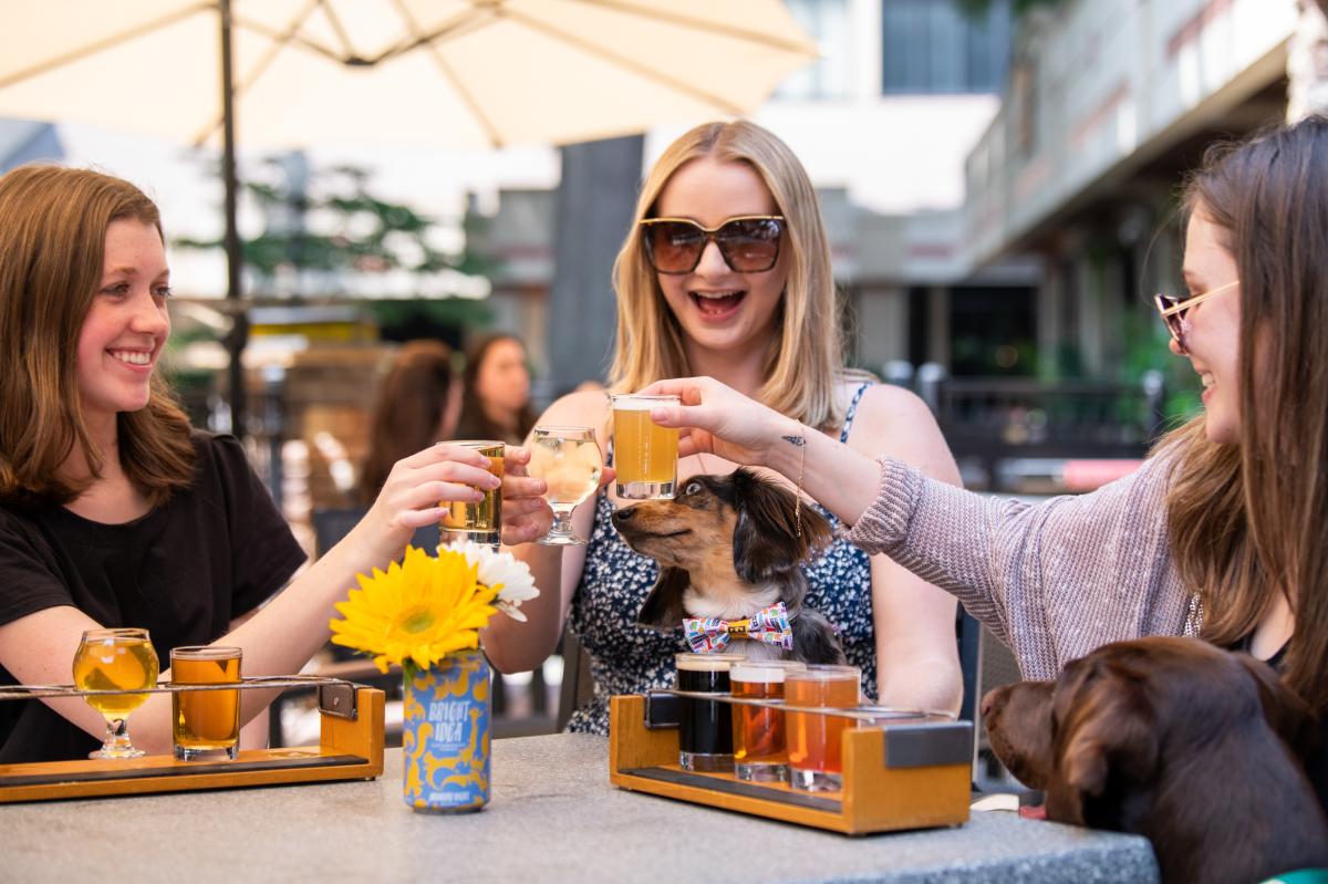 The Brass Tap Women Cheers with Beer and Dogs