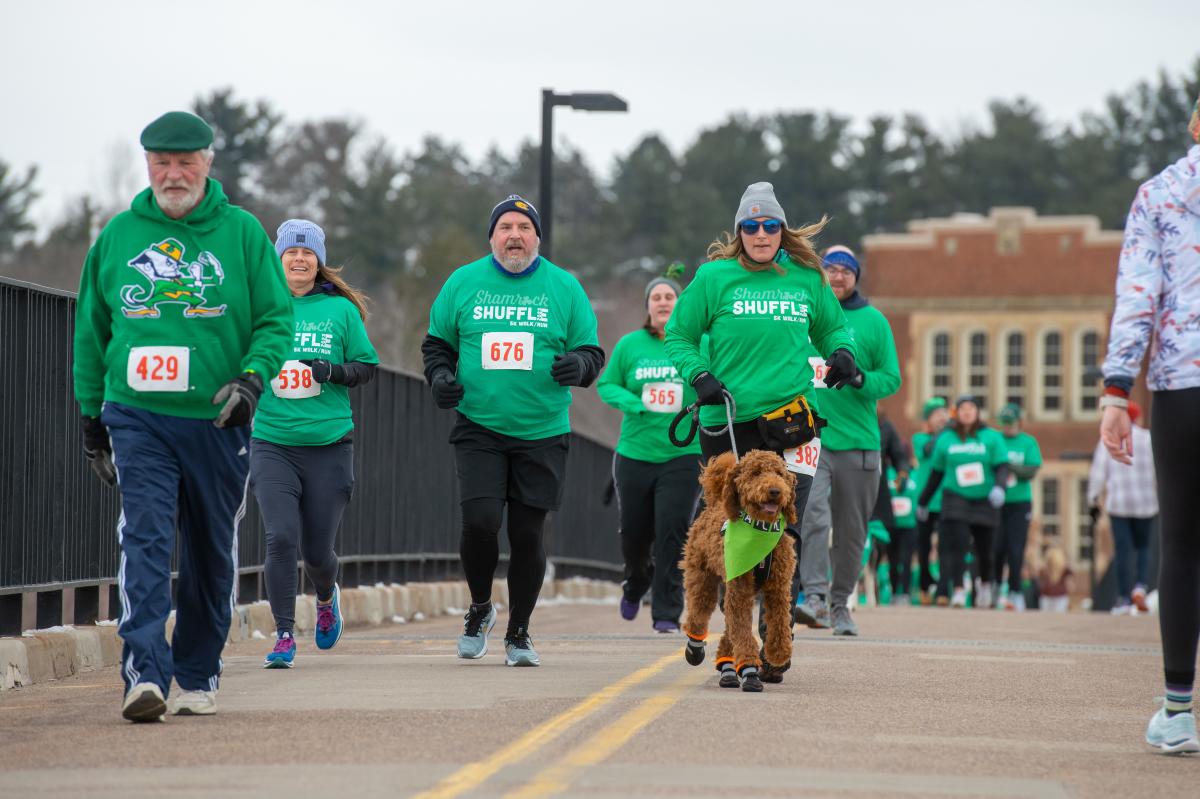 A group of participants running across the bridge in the Shamrock Shuffle