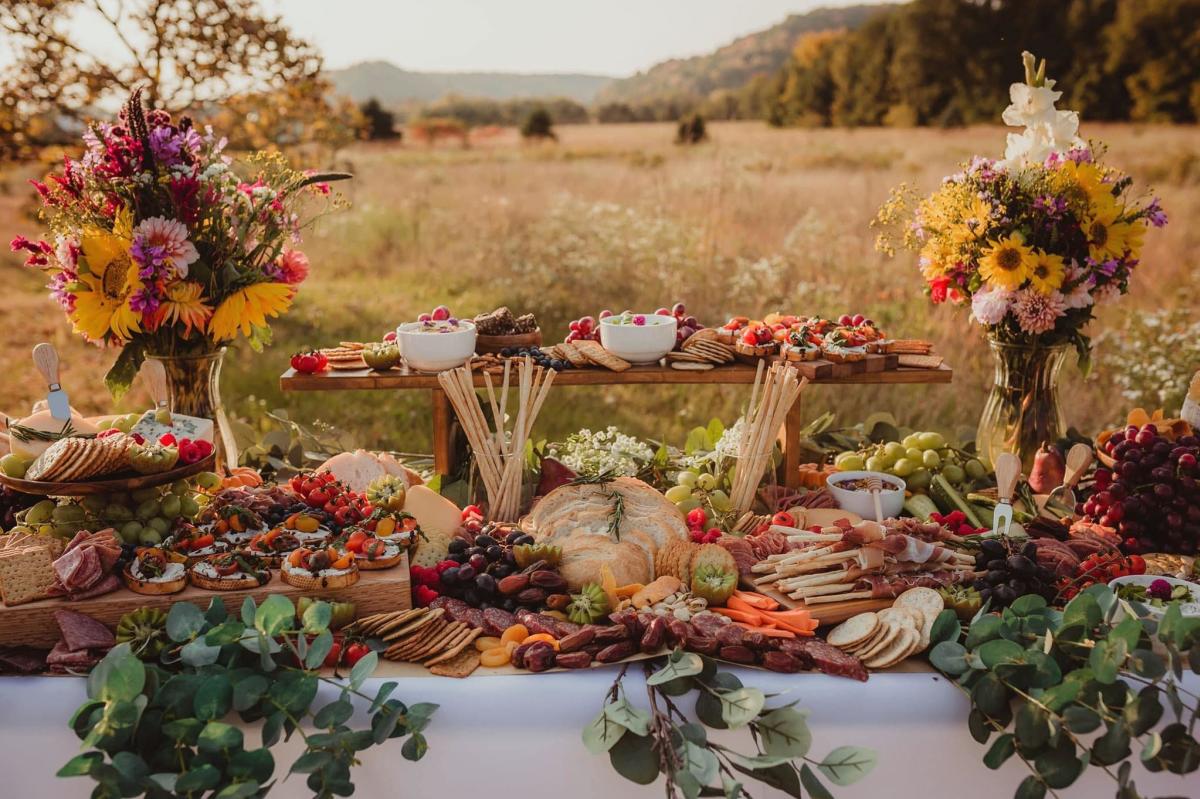 A gourmet grazing table in a scenic outdoor landscape