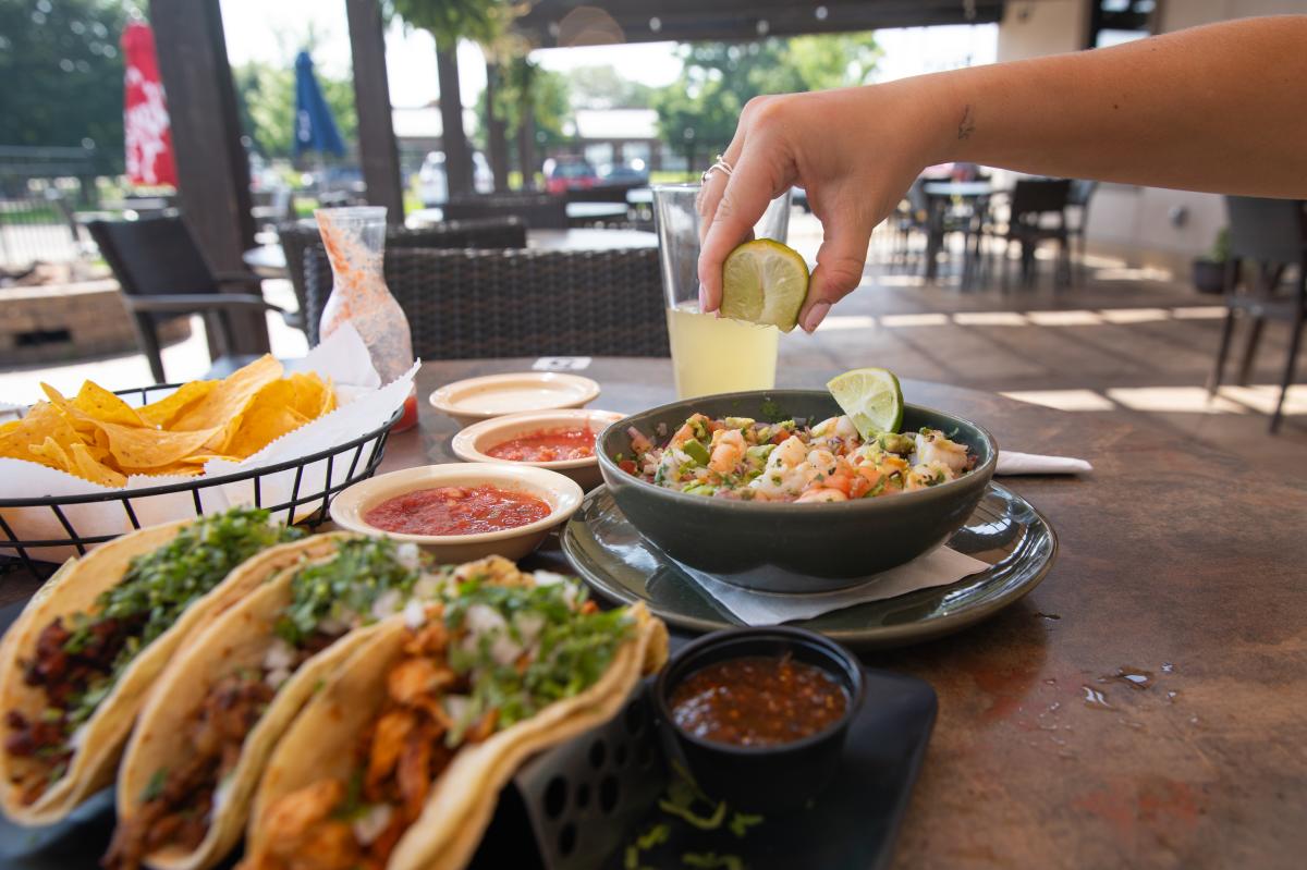 A girl squeezing a lime over food at Cancun's patio