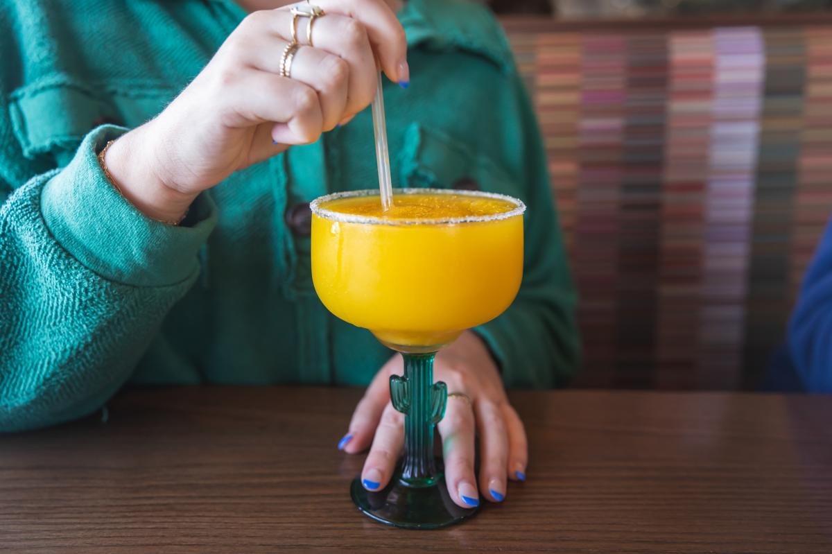 A girl holding a frozen margarita at Cancun Mexican Grill