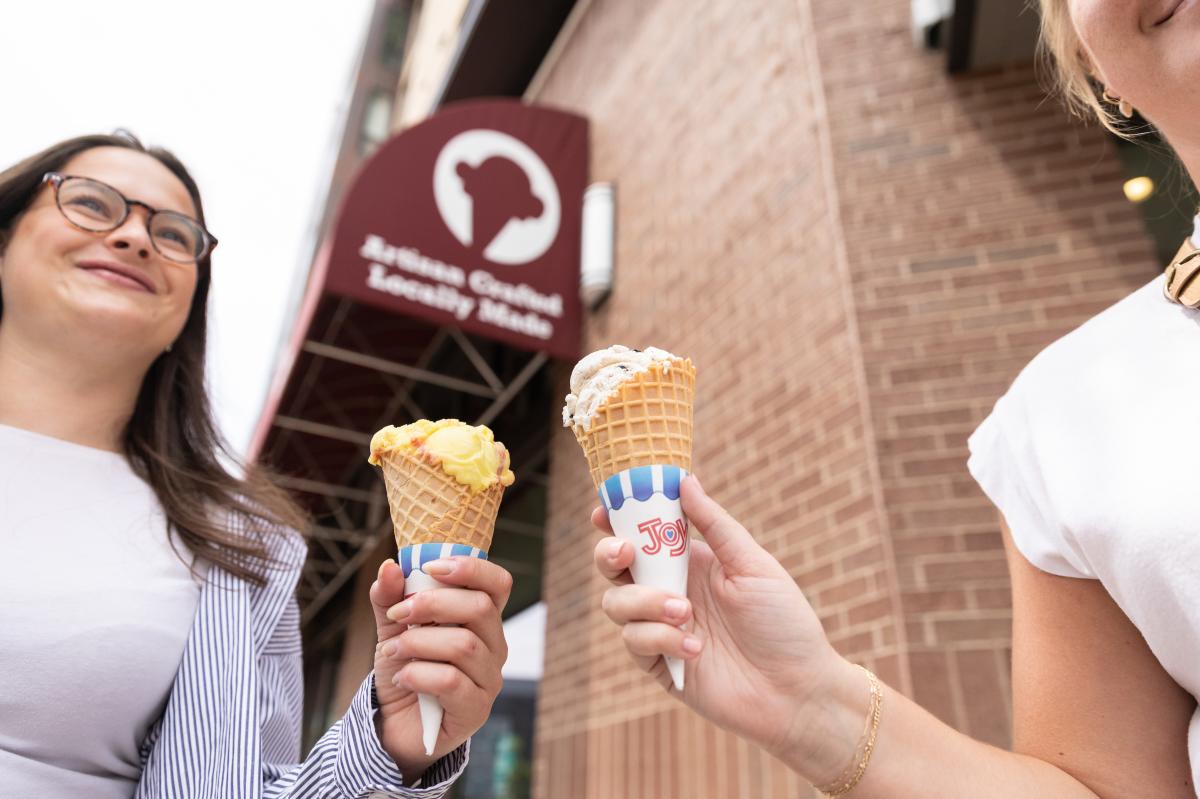 two girls holding ice cream cones outside of Olson's Ice Cream