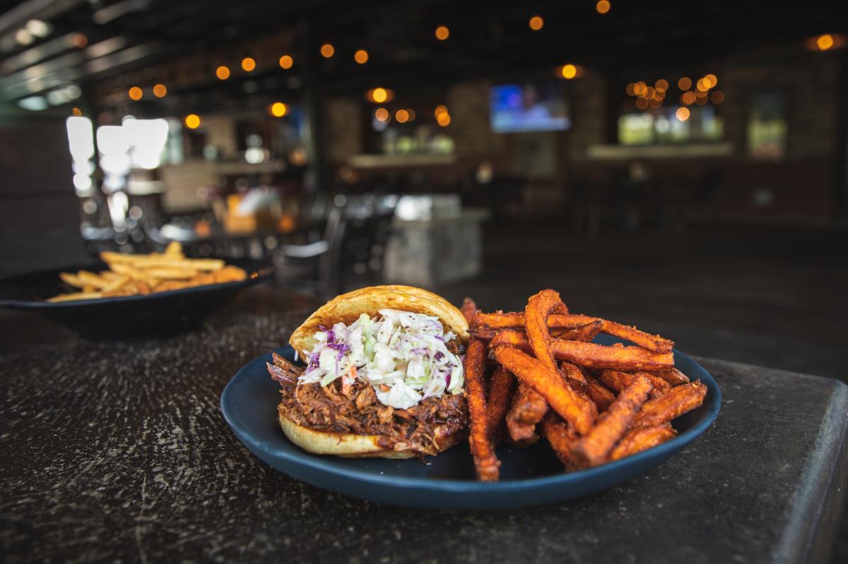 Pulled pork sandwich served on the outdoor patio at Cowboy Jack's in River Prairie