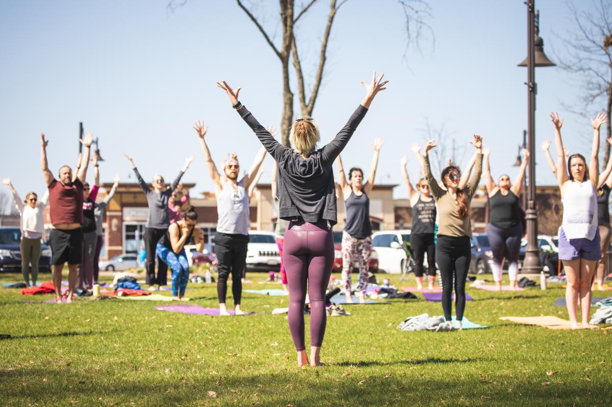 A group of people taking a yoga class on the lawn in River Prairie