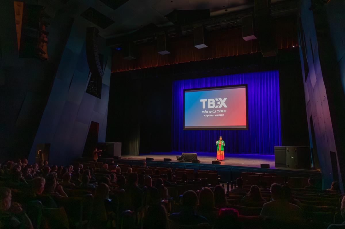 A person on stage presenting at TBEX