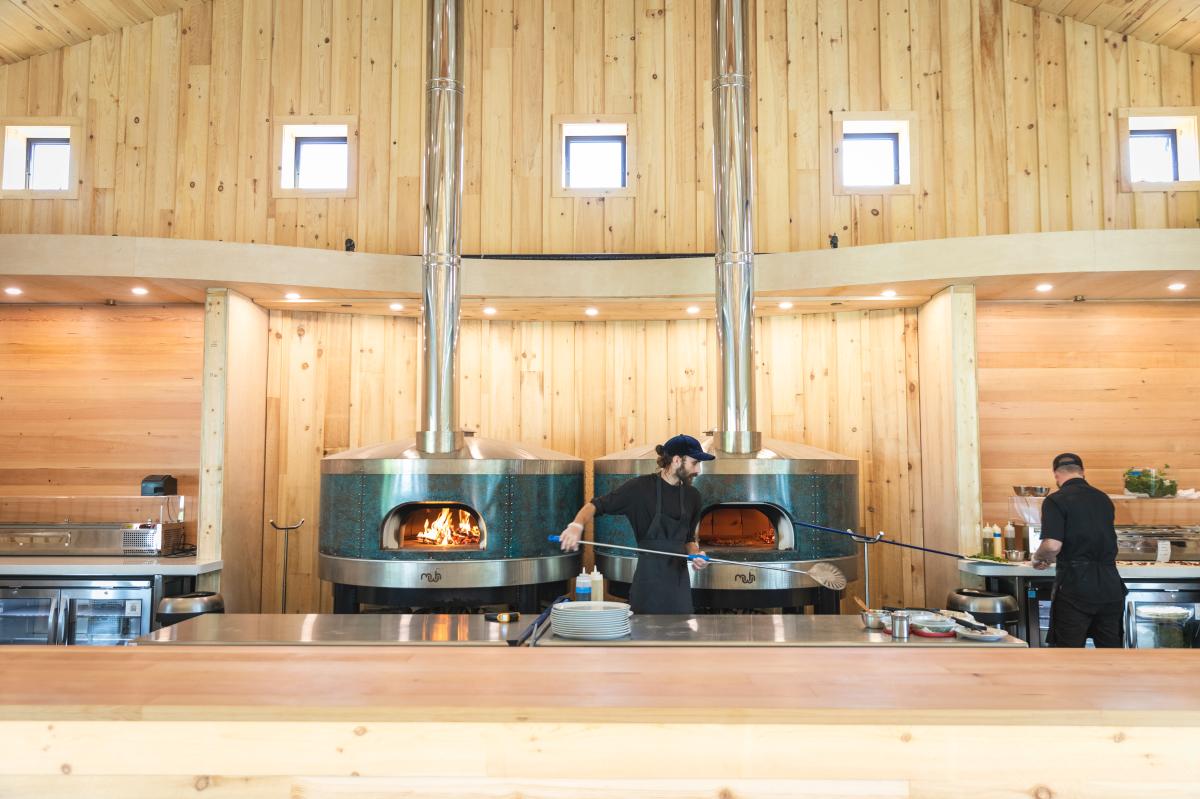 a guy making pizza in the oven at Lucette Brewing Company