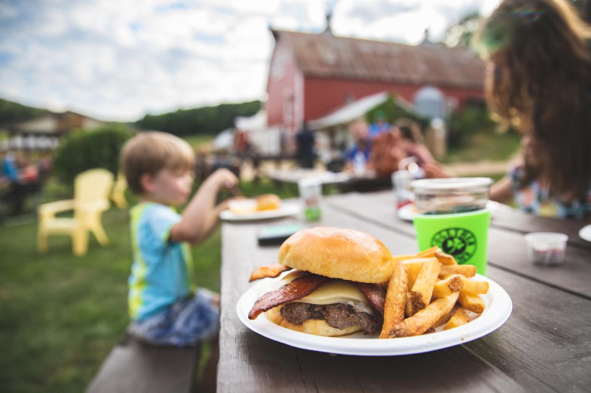 A burger served at a table outside at Together Farms in Mondovi