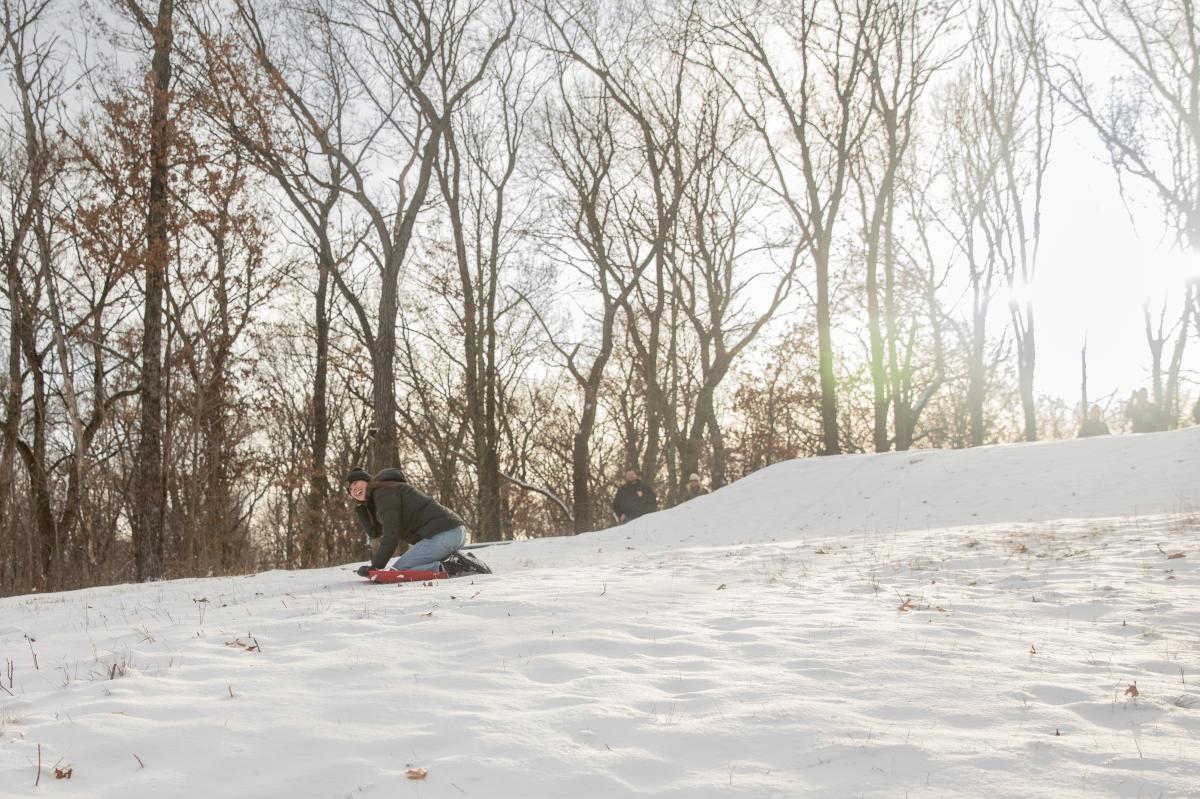 A girl sledding at the hill at Wheaton Park