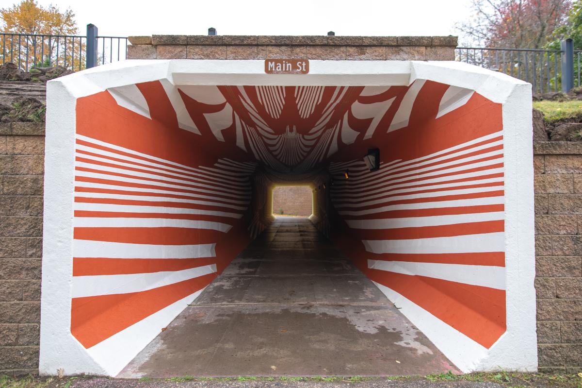 A red and white mural throughout a tunnel in Boyd Park
