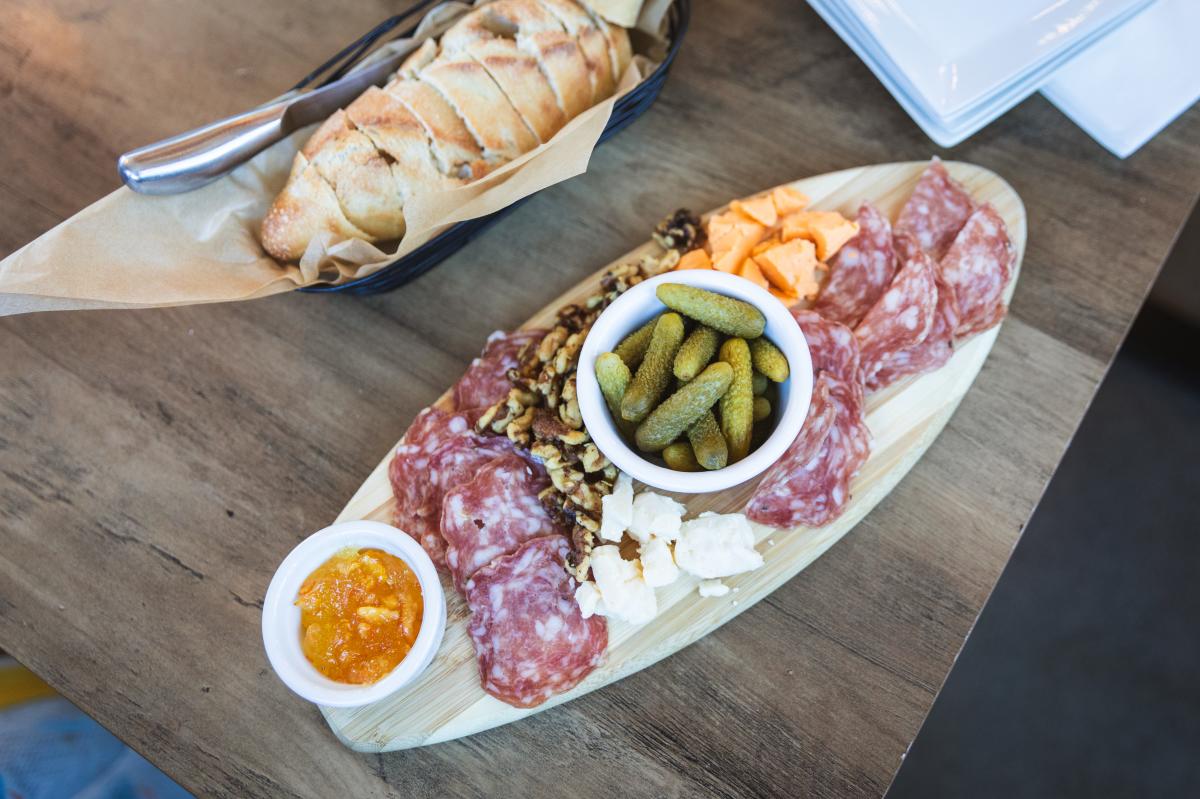 A photo of a cheese board with meats, pickles, and dips at Helix