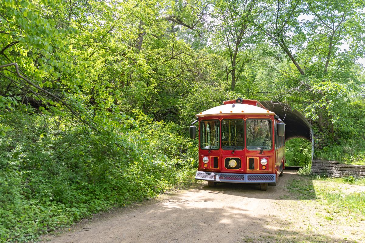 A red trolley going through the tunnel in Putnam Park