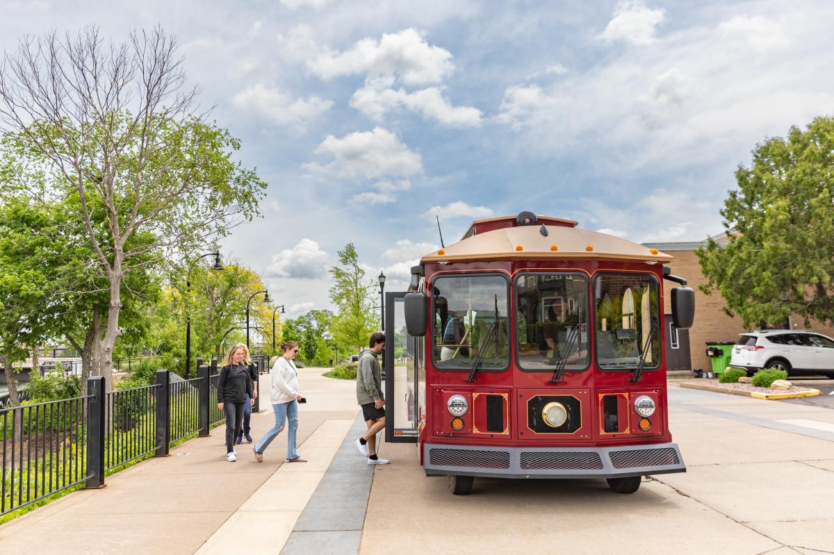 3 people stepping aboard the Chippewa River Trolley