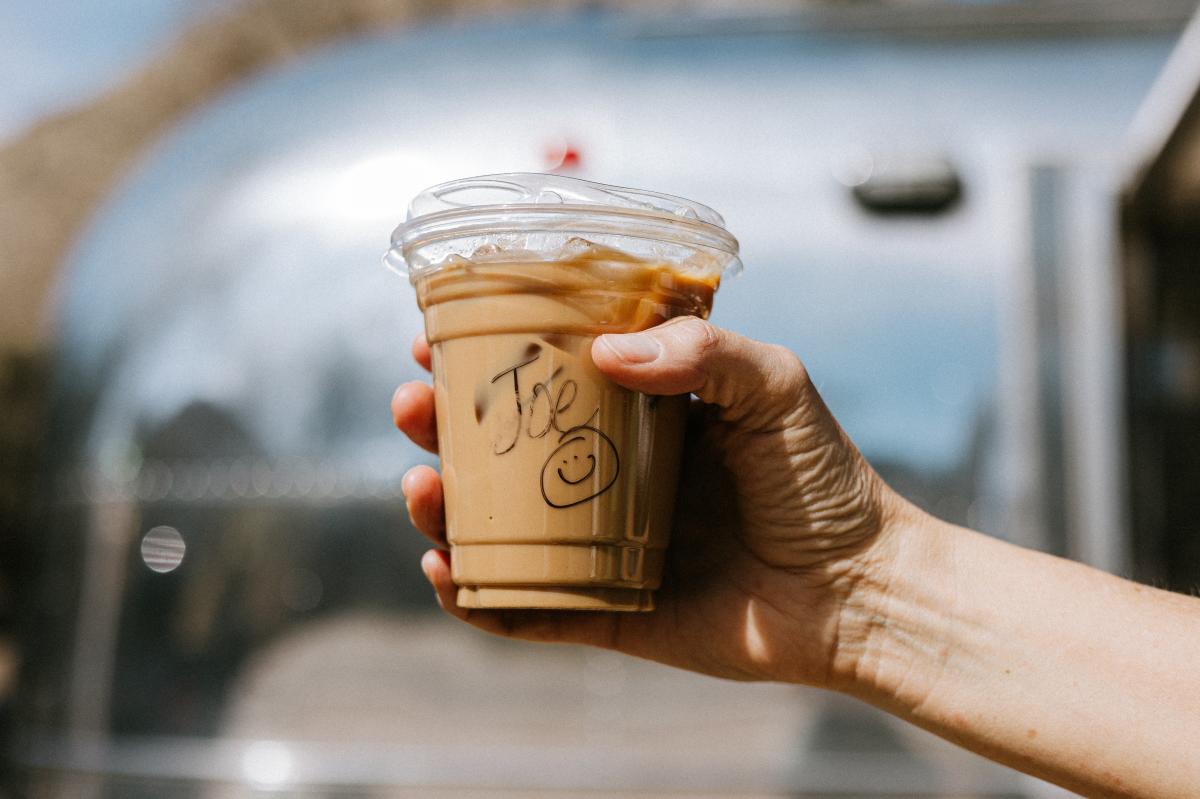 a plastic cup of coffee that has the name Joe written on it with a smiley face