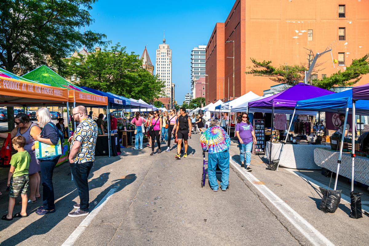 People browsing the outdoor YLNI Farmers Market