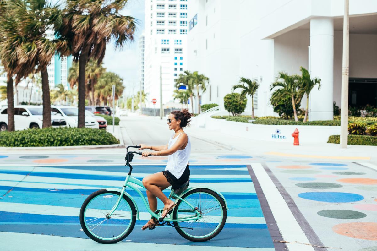 A woman bike riding on the beach