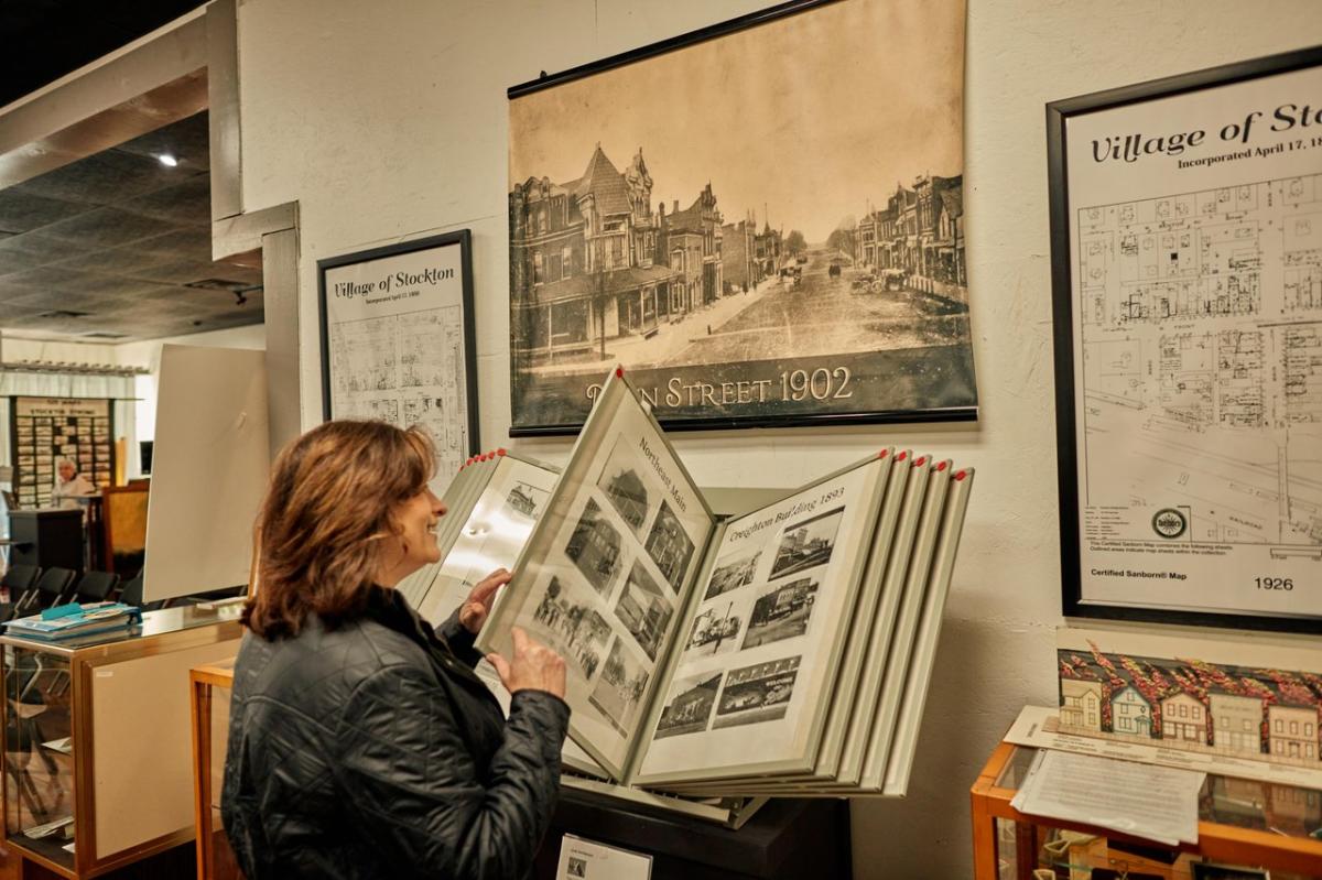 Person looking at a large historical book in a museum.