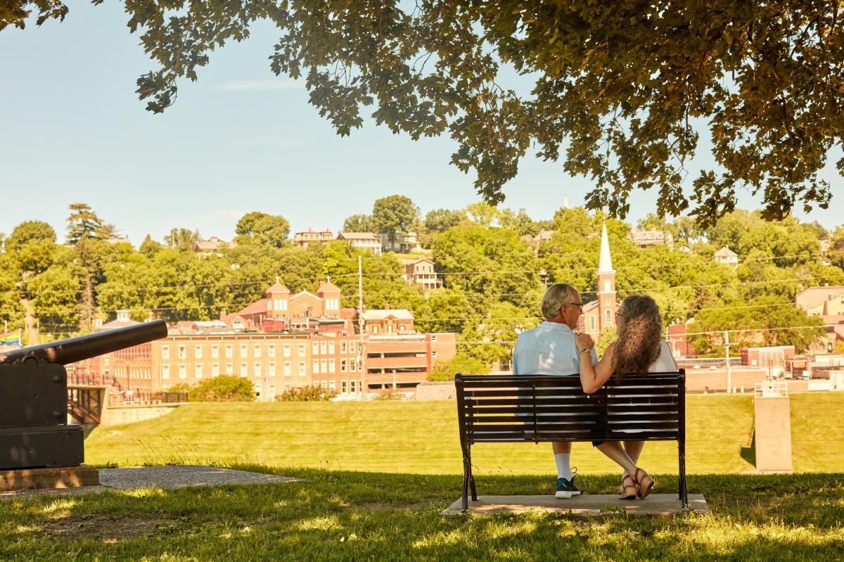 A couple sitting on a bench overlooking downtown Galena, from Grant Park.