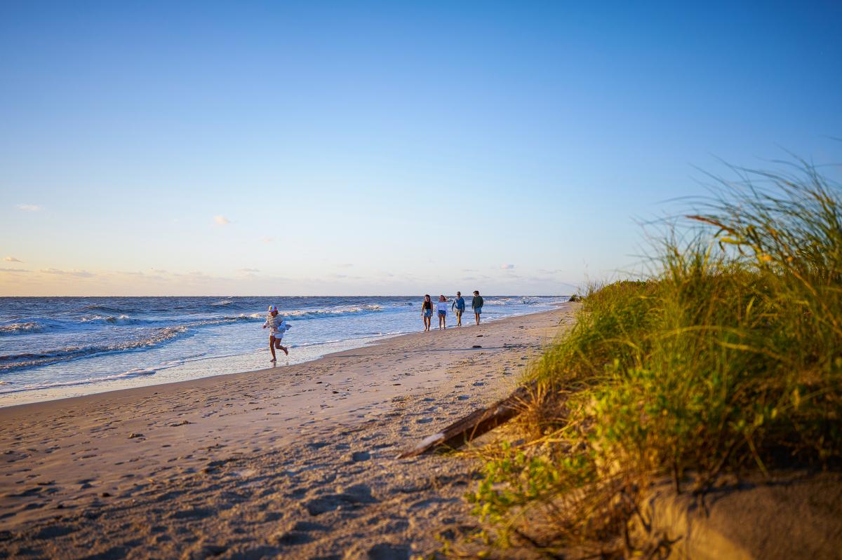 A family walks along the undeveloped beach on Little St. Simons Island, GA