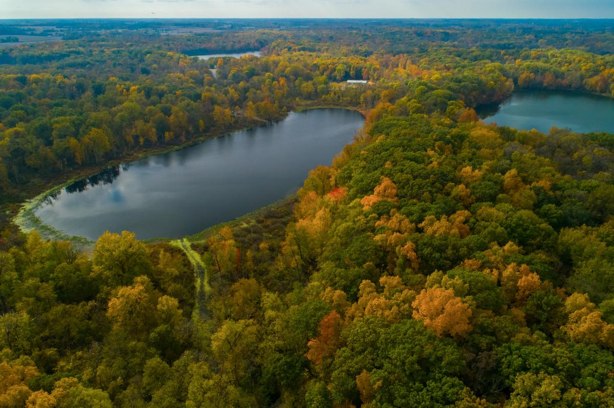 Aerial view of lakes surrounded by colorful fall foliage at Chain O’Lakes State Park.