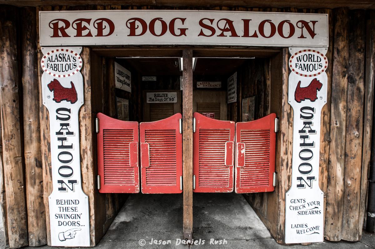 The entrance to Red Dog Saloon complete with red swinging doors and a rustic exterior. 