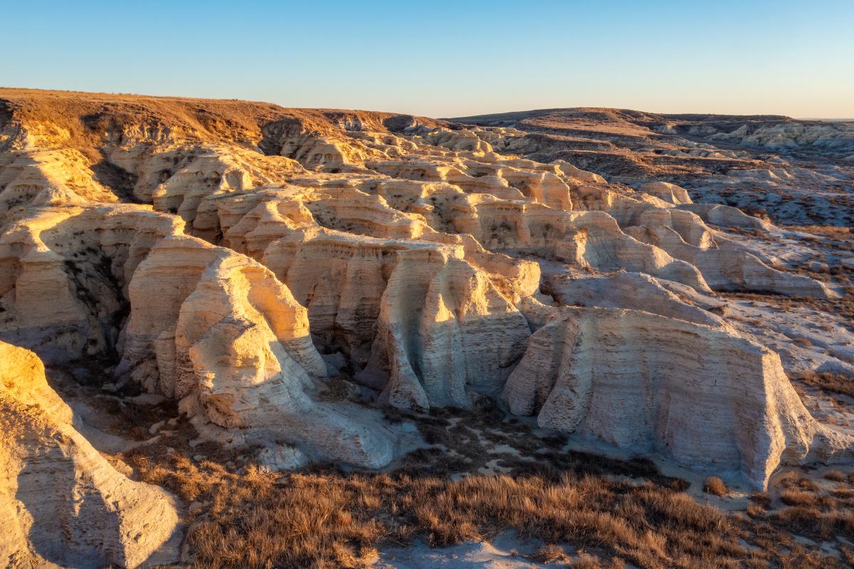 Rocky outcroppings of chalk formation landscapes, golden sunlight is cast on the rocks