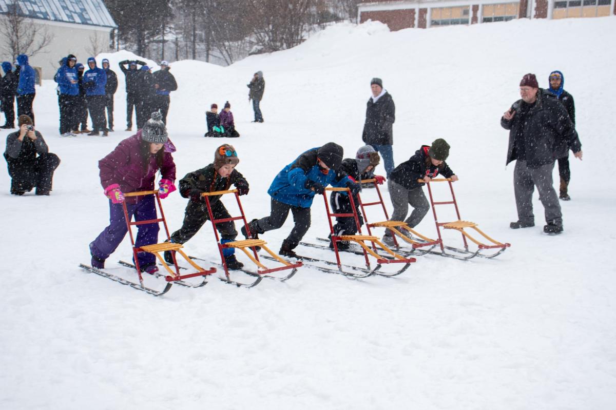 Children race on kick sleds during Heikinpaiva