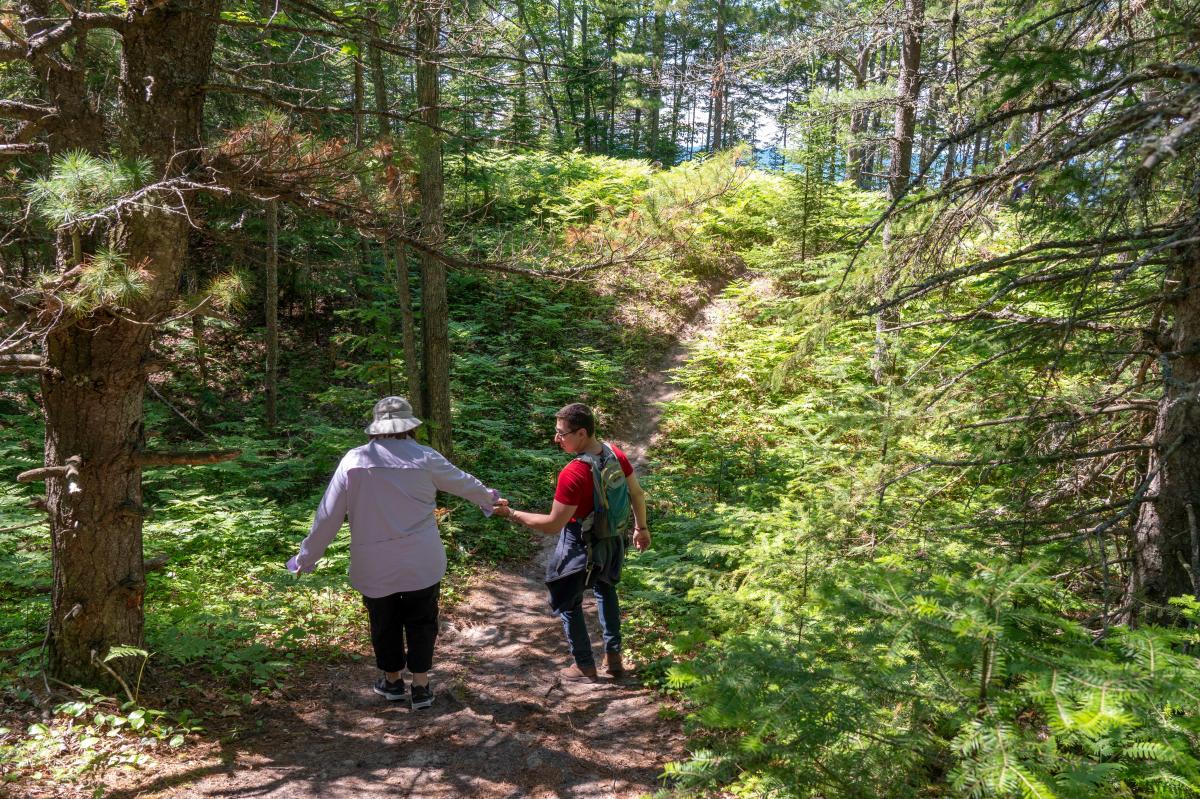 Man helps woman during hike at Black Creek Nature Sanctuary