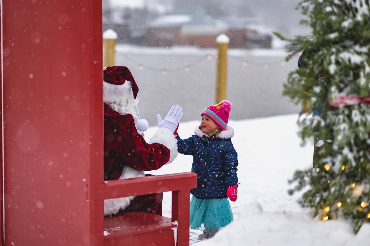 a small child high fives santa