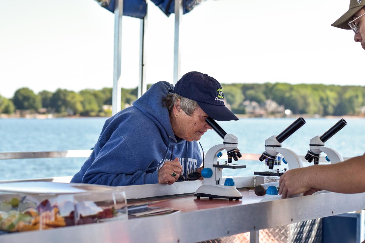 Women looking into microscope on the Catawba Riverkeeper Floating Classroom on Lake Norman.