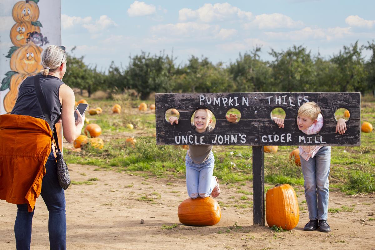 Kids posing as Pumpkin Thiefs while mom takes their photo