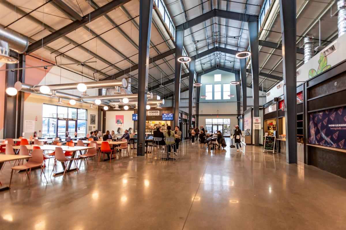 interior food hall with high industrial ceilings and cafeteria style seating