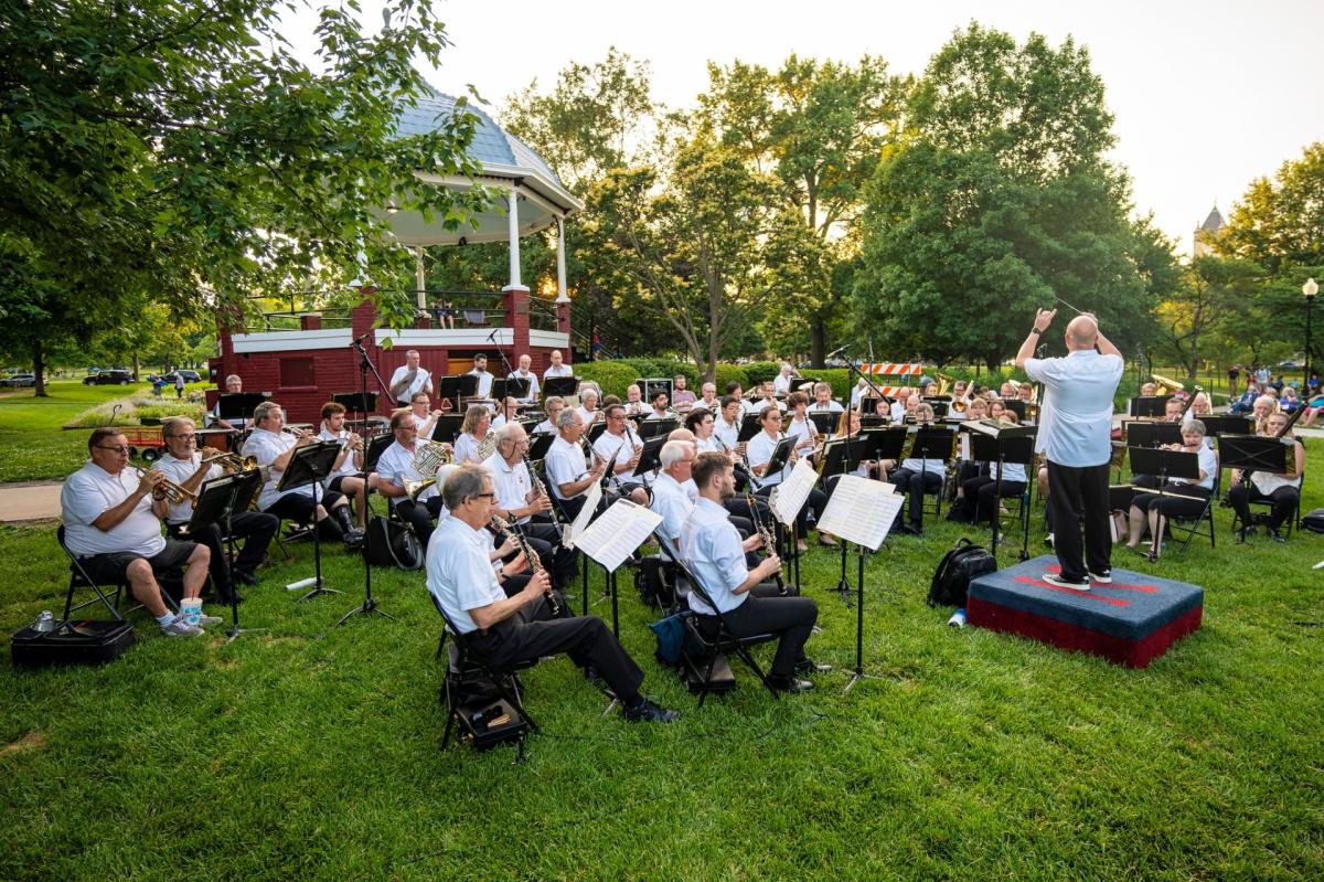 Photo features the Lawrence City Band playing music in front of the iconic red gazebo in South Park in Lawrence, Kansas.