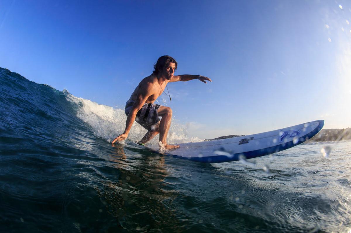 surfista sobre tabla en una ola en el mar