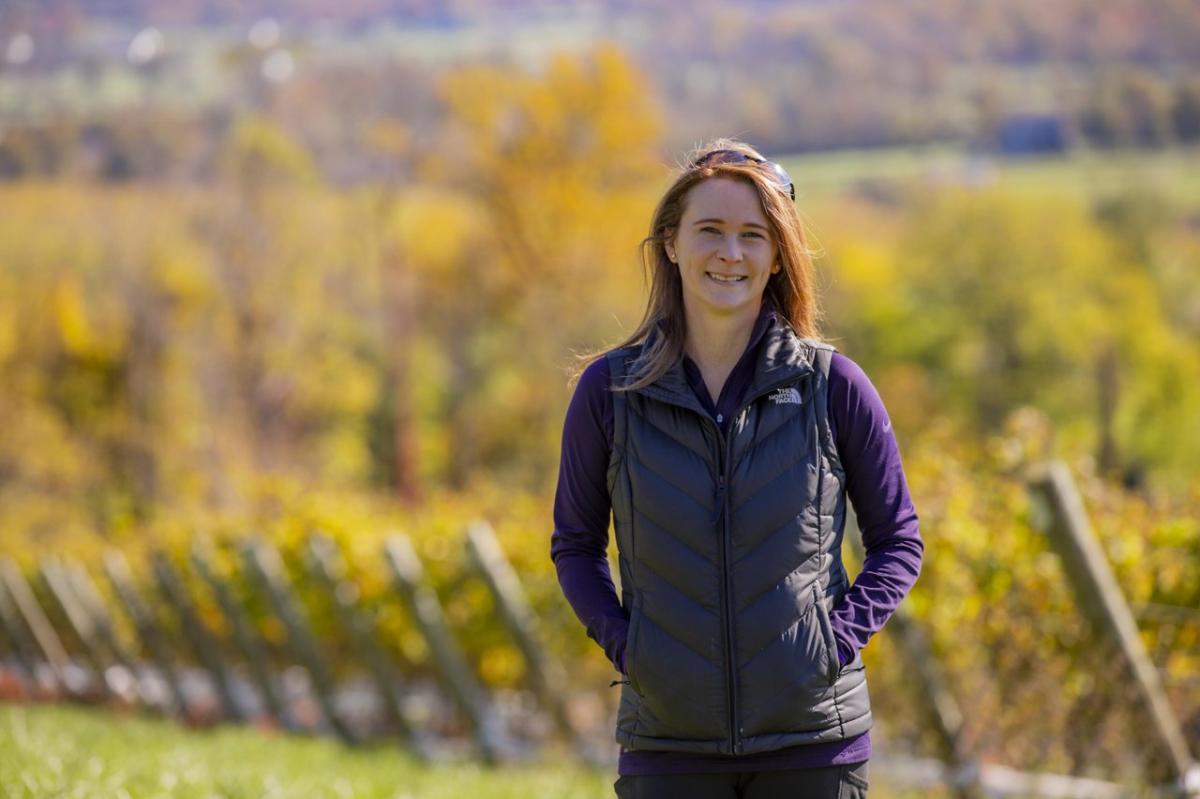 Aimee Henkle of The Vineyards and Winery at Lost Creek standing among vineyard rows in Loudoun County