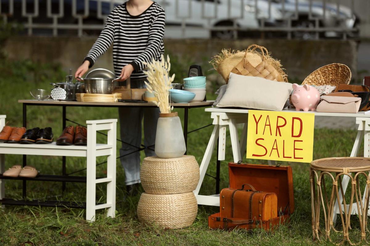 Woman placing things on table at yard sale