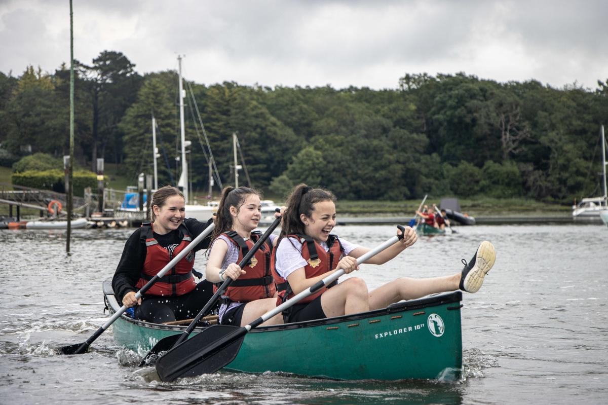 Group of teenagers canoeing on the Beaulieu River with New Forest Activities