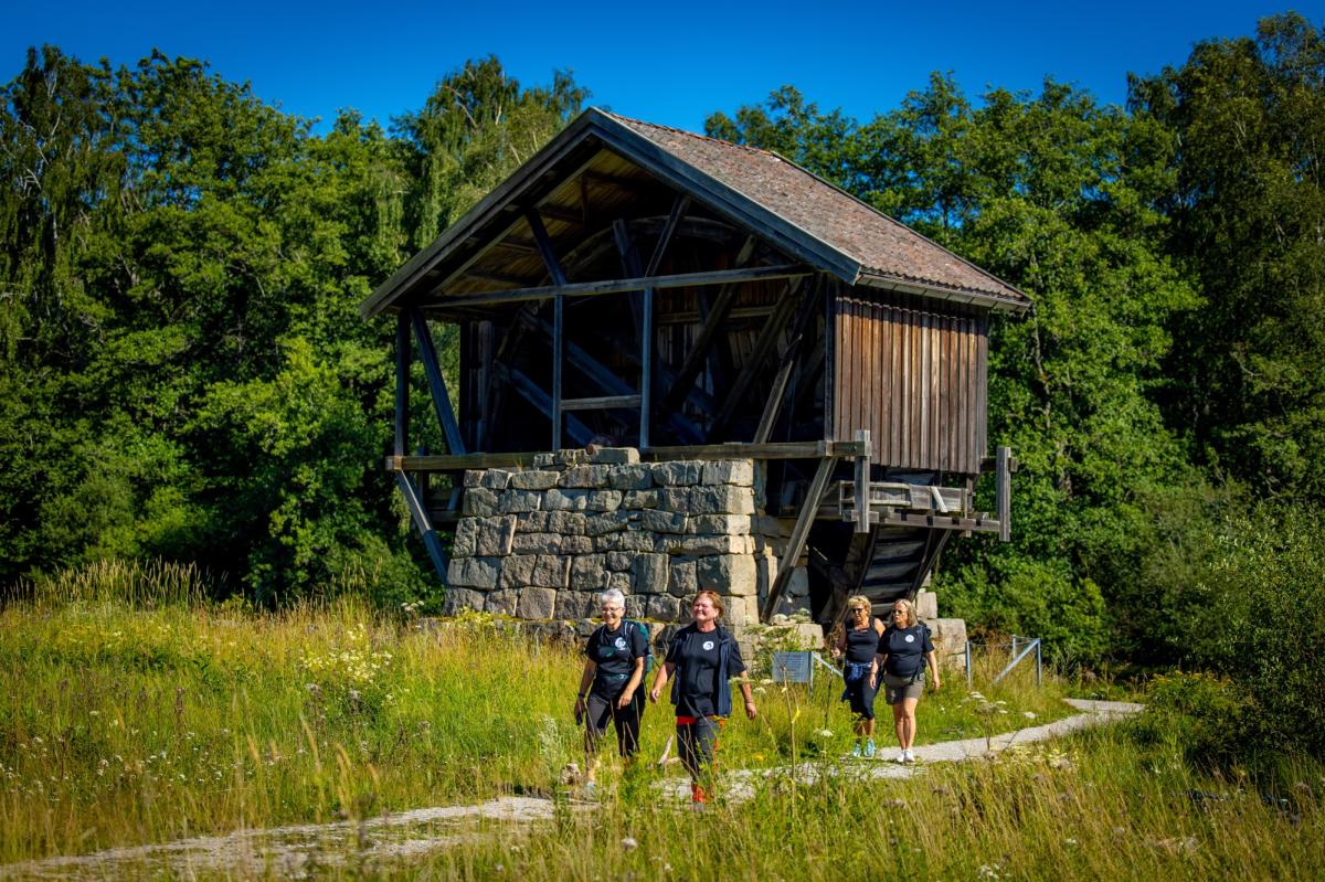 Fire pilegrimsvandrere langs stien ved Soli Brug, med den gamle mølla i bakgrunnen.