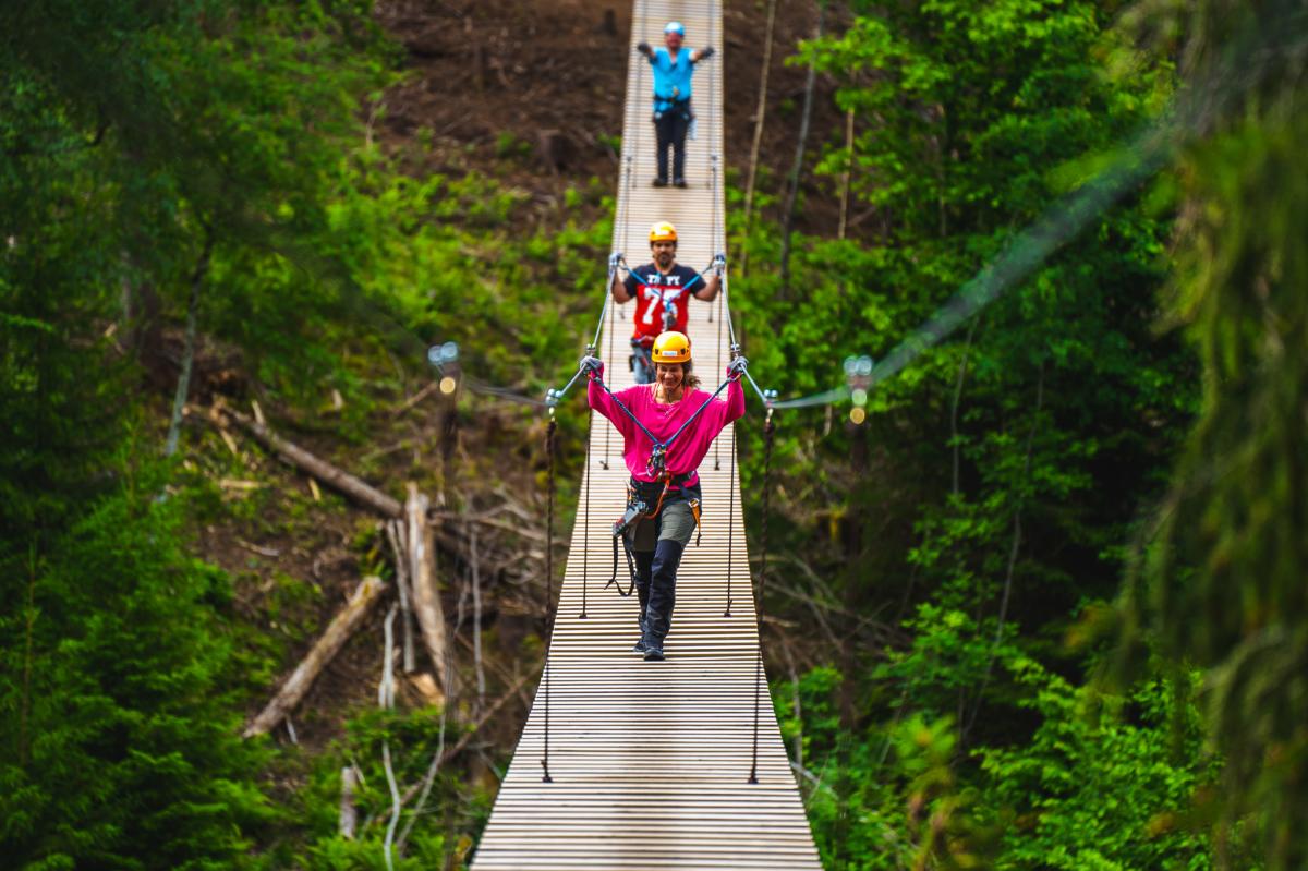 Tre personer på hengebroen i Via Ferrata Haldenkanalen