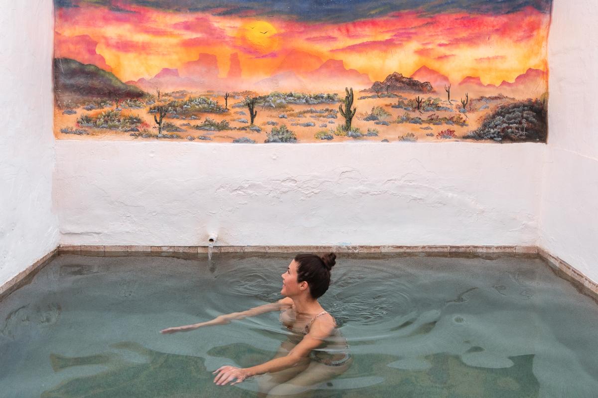 Woman soaking in private pool at Delights Hot Springs in Tecopa, California