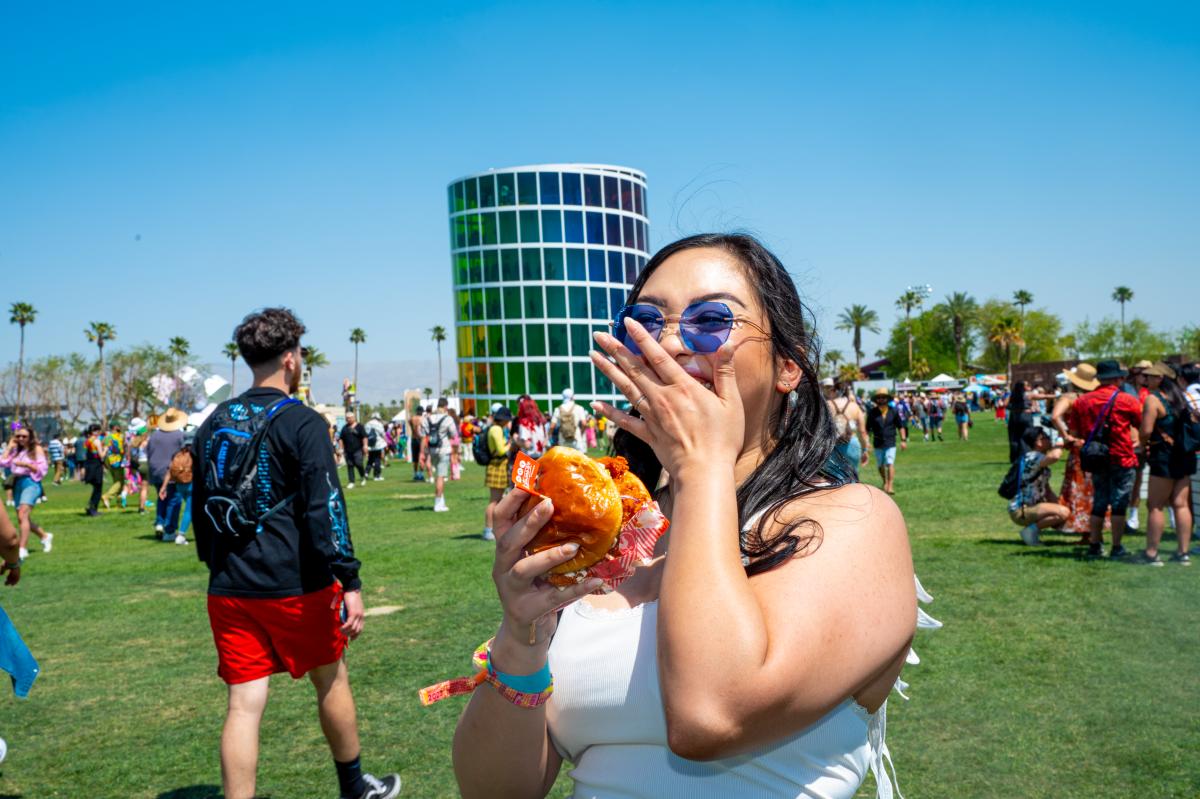 A Coachella festivalgoer enjoys food from Hattie B's in 2023.