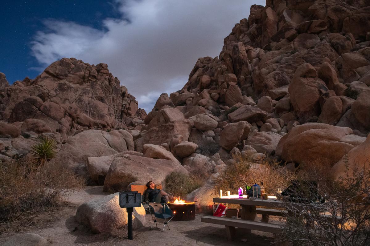 A camper by the fire at Indian Cove Campground in Joshua Tree National Park