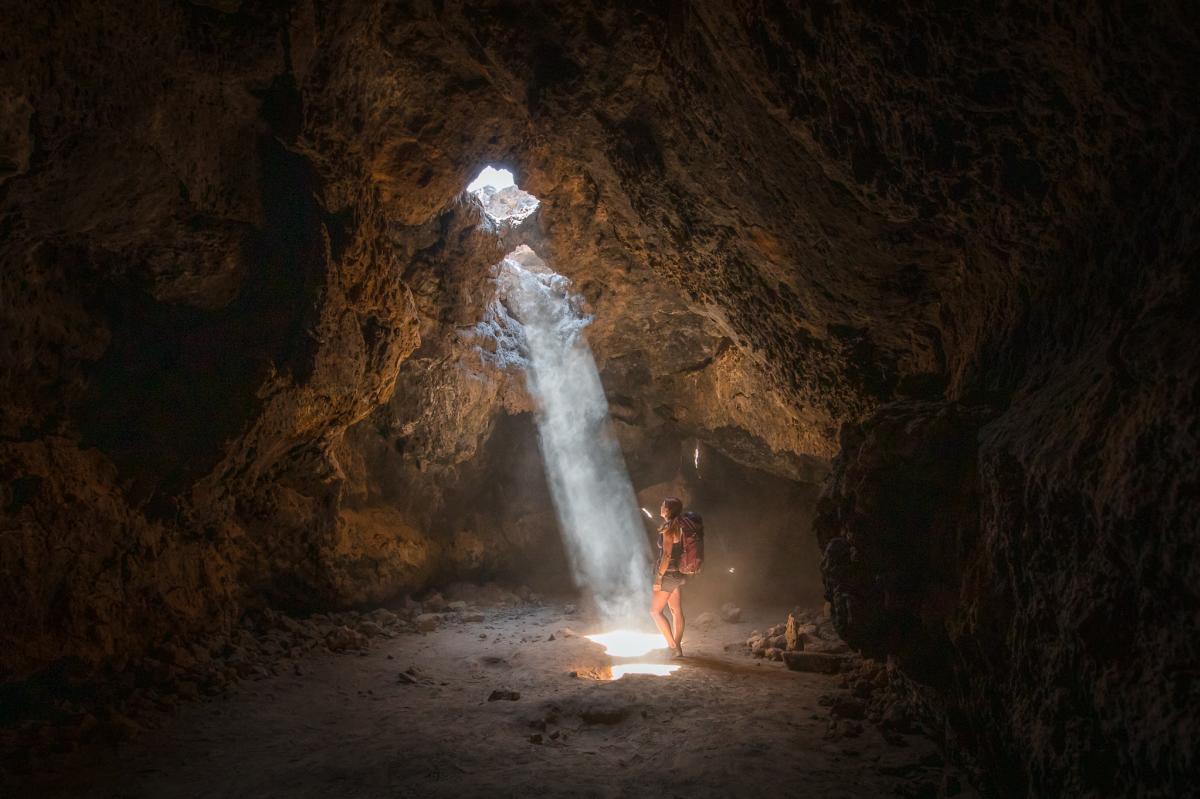 A hiker stands inside the Lava Tube in the Mojave National Preserve