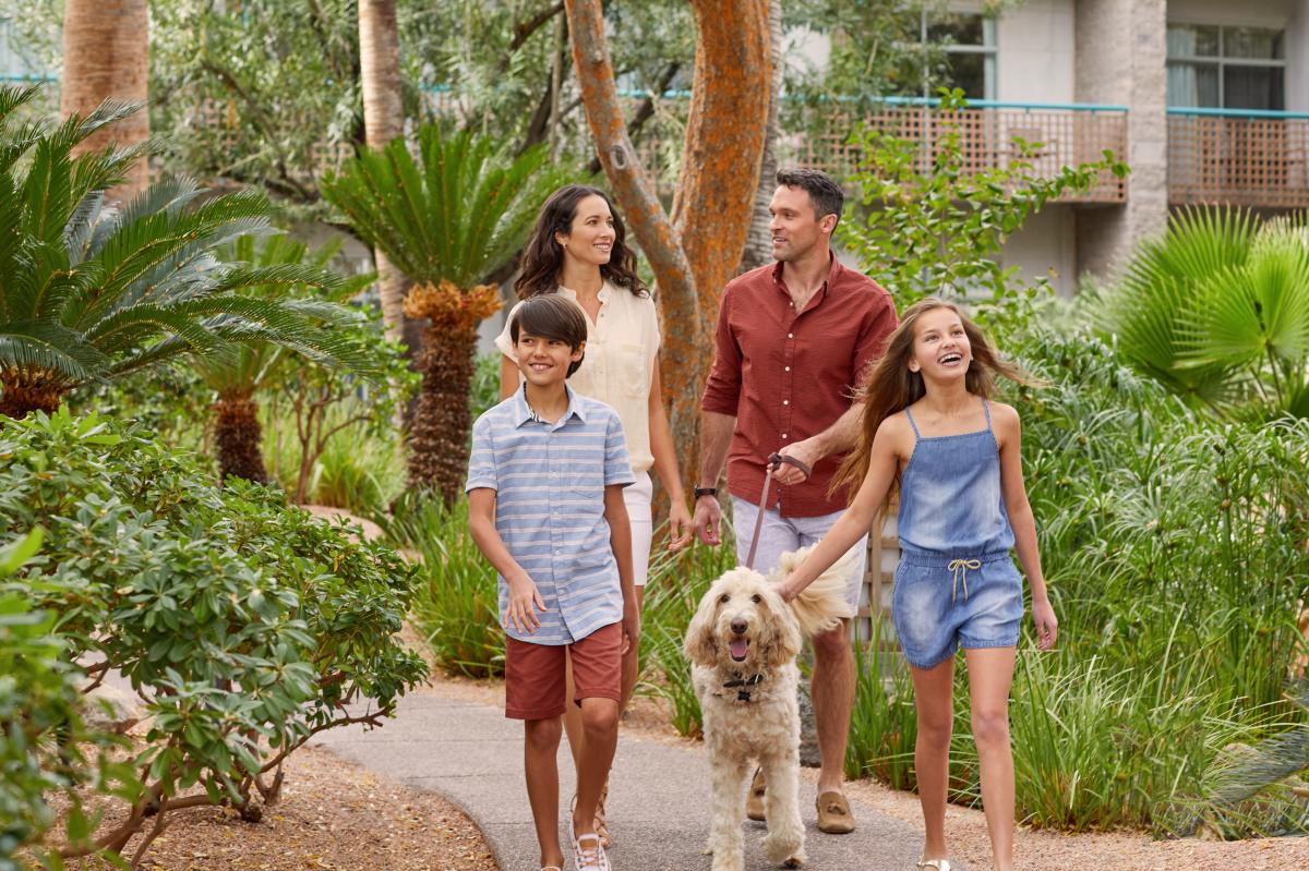 Family walking dog throughout resort walkways