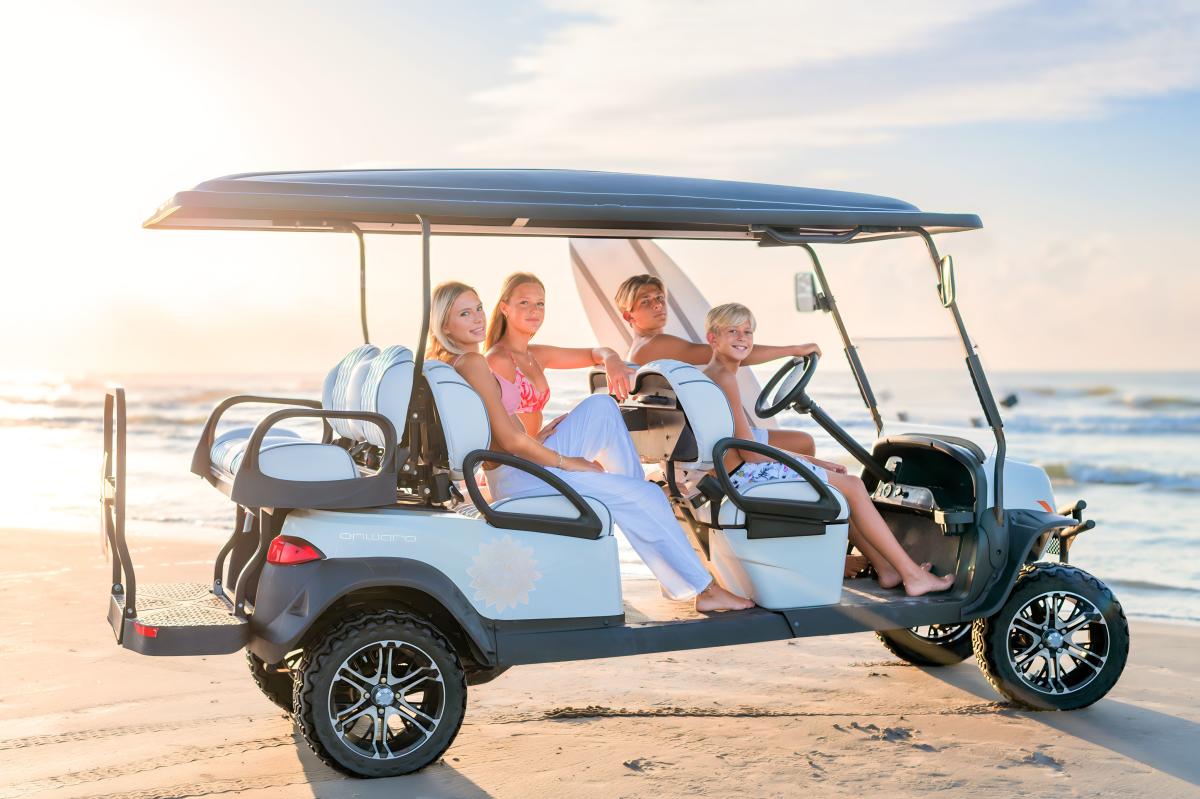 Gold cart with family sitting in it holding a surf board.