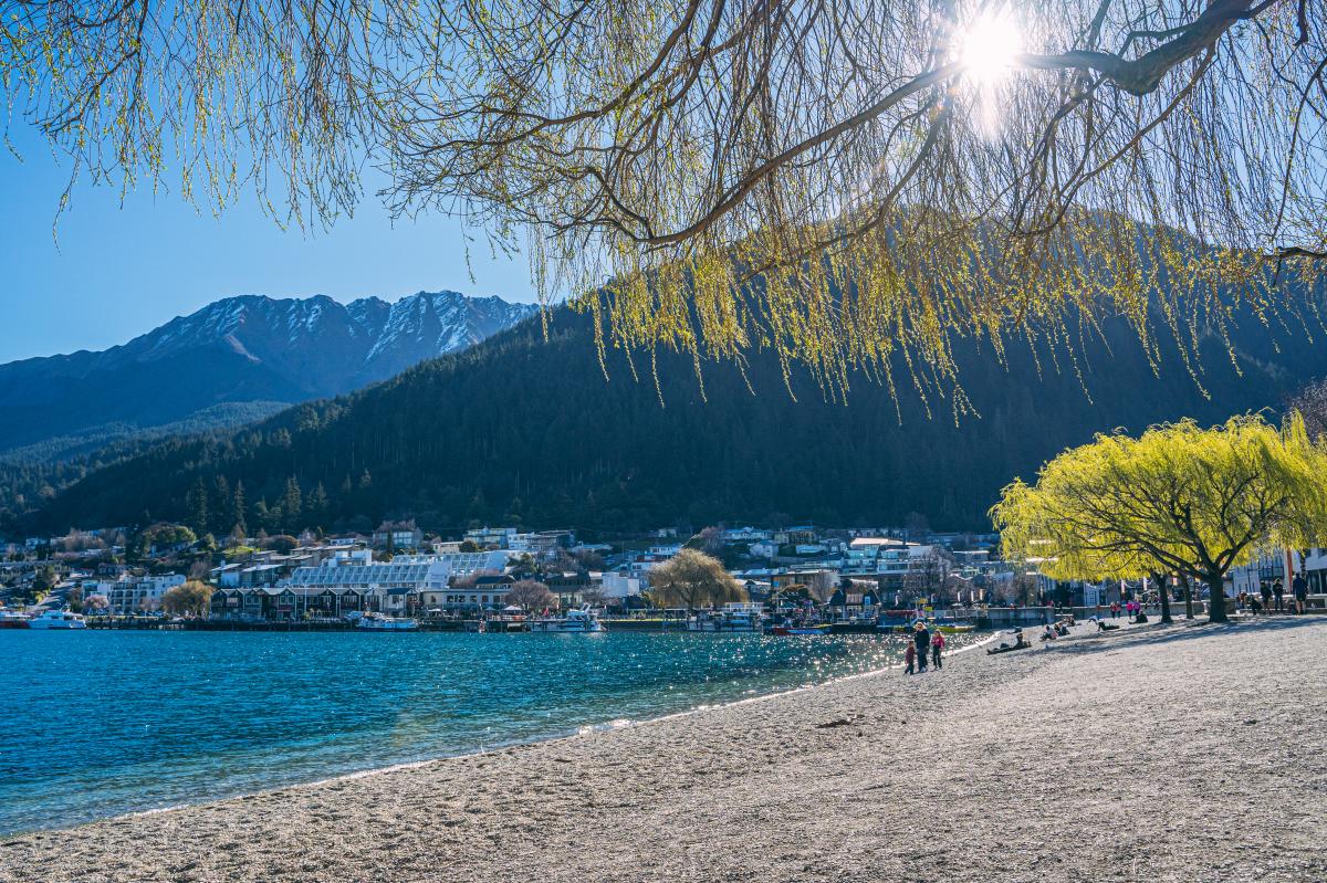 Queenstown Lakefront in Spring with blue lake and snow capped mountains in the distance