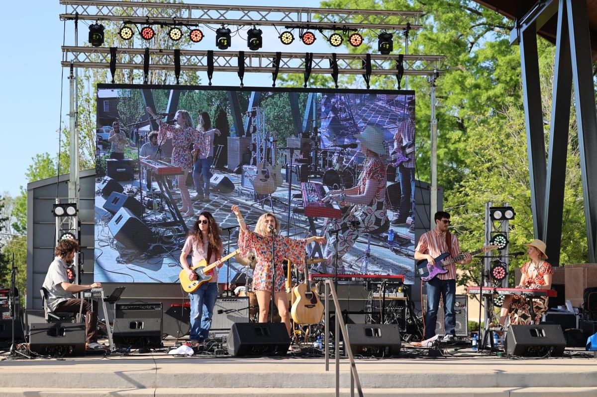 Band performing on stage at Bell Tower Green